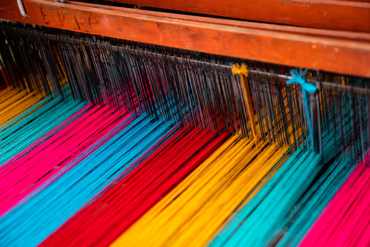 Brightly coloured threads on a weaving loom